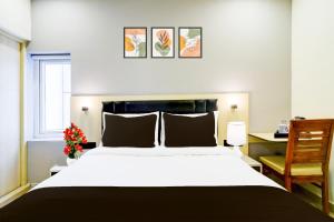a bedroom with a large white bed and a desk at Townhouse Aarav Business Hotel in Hyderabad