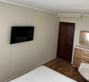 a bedroom with a bed and a television on the wall at Простора та стильна 2 кімнатна в центрі Черкас на бульварі Шевченко з панорамним видом та СмартТВ! Дві окремі охайні спальні з кондиціонерами,поруч парковка з охороною in Cherkasy