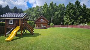 a playground with a slide and a house at Namelio-mini vilos nuoma in Palanga