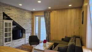 a living room with a couch and a tv at Namelio-mini vilos nuoma in Palanga