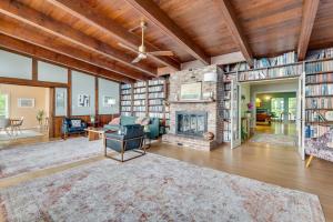 an open living room with a fireplace and bookshelves at Scenic, Spacious Riverside Retreat Ropeyarn in Deltaville