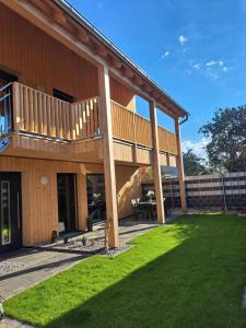 a house with a deck and a grass yard at Ferienhaus Brunner in Höchst
