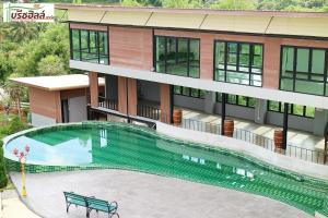 a building with a swimming pool in front of a building at Breezehill Khao Kho Hotel in Khao Kho