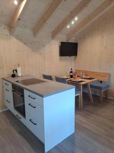 a kitchen and dining room with a table and a tv at Ferienhaus Brunner in Höchst