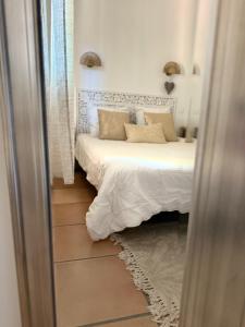 a bedroom with a bed with white sheets and a mirror at Bavella in Zonza +12 photos