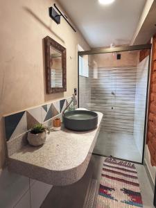 a bathroom with a sink and a tub and a shower at Vila Amor - Charmosa e Central in Alto Paraíso de Goiás +143 photos