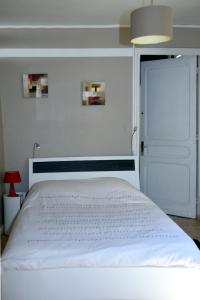 - une chambre avec un lit blanc et une porte blanche dans l'établissement Chambres d'hôtes L'Escale Malouine, à Dunkerque