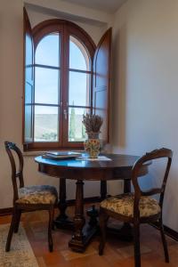a dining room table with two chairs and a vase on it at Tolaini Winery Suites in Castelnuovo Berardenga +16 photos