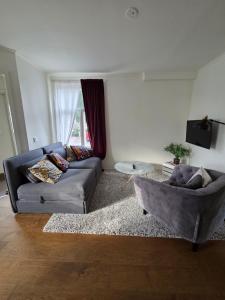 a living room with a couch and a table at 3A Centralt Boende i Dala-Floda! in Djuras