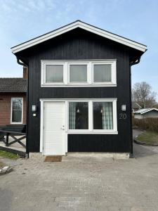 a black house with a white door and a window at Happy stay apartment in Vallda