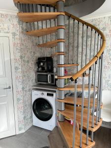 a spiral staircase in a laundry room with a washing machine at Happy stay apartment in Vallda +9 photos