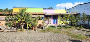 a colorful house with trees in front of it at 龍磐1號民宿 全家出遊首選1至12人包棟 均一價 免爬梯獨棟平房 三間獨立套房 寬敞庭院可烤肉 in Eluan