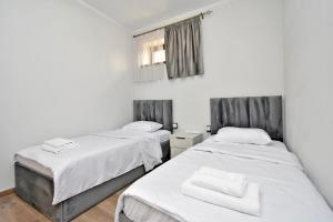 two beds in a room with white walls at Zvartnots International Hotel in Pʼarakʼar