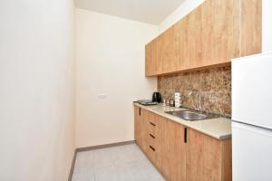 a kitchen with a sink and a refrigerator at Zvartnots International Hotel in Pʼarakʼar