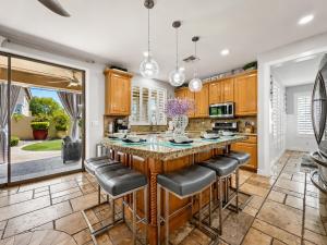 a kitchen with a large island with leather bar stools at The Jade House Queen Creek in Queen Creek