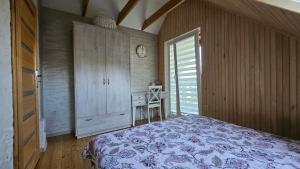 a bedroom with a bed and a cabinet and a window at Namelio-mini vilos nuoma in Palanga