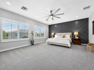 a bedroom with a white bed and a ceiling fan at The Jade House Queen Creek in Queen Creek