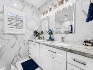 a white bathroom with marble walls and a sink at The Jade House Queen Creek in Queen Creek +43 photos