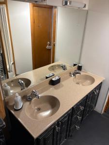 a bathroom with three sinks and a large mirror at Winnie baygo Meadow view in Hurst