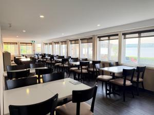a dining room with tables and chairs and windows at Sleep Inn & Suites Quebec City East in Boischâtel