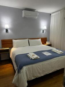 a bedroom with a bed with two towels on it at Pepe Hostel Boutique in Neuquén +28 photos