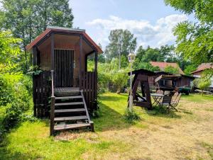 a wooden out house with a ladder and a swing at Radler-Pension in Lübbenau