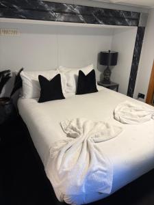 a bedroom with a white bed with black pillows at Winnie baygo Meadow view in Hurst