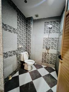 a bathroom with a toilet and a checkered floor at Mhamid 4 in Marrakesh +6 photos
