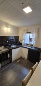 a kitchen with black and white counters and a stove at Batilana 2 in Neuquén