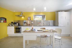 a kitchen with yellow walls and a table and chairs at Chez Castagné in Issor