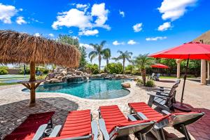 a resort pool with chairs and a red umbrella at 104th Mesa 1331 Paradise Found in Mesa