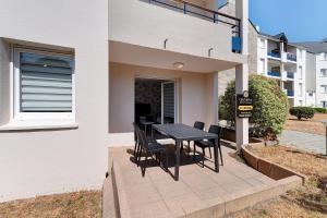 a patio with a table and chairs next to a building at Les Marines Du Crouesty in Arzon