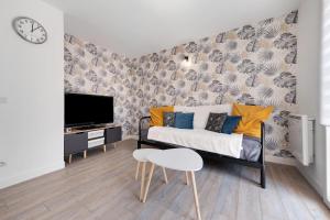 a living room with a couch and a tv at Les Marines Du Crouesty in Arzon