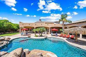 an outdoor pool with chairs and umbrellas in front of a house at 104th Mesa 1331 Paradise Found in Mesa
