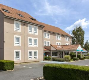 an image of a hotel with a parking lot at BRIT HOTEL Confort CAMBRAI in Cambrai