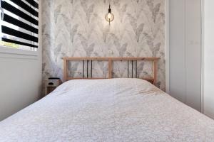 a bedroom with a bed and a wall at Les Marines Du Crouesty in Arzon