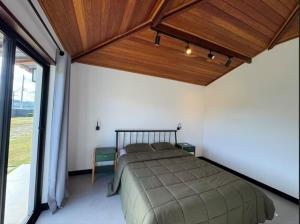 a bedroom with a bed and a large window at Nosso Loft Sebollas - 4C in Paraíba do Sul