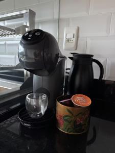 a coffee maker and a cup of coffee on a counter at Nosso Loft Sebollas - 4C in Paraíba do Sul