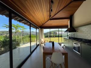 a kitchen with a wooden table and some chairs at Nosso Loft Sebollas - 4C in Paraíba do Sul