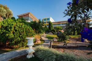 a garden with a white vase in front of a building at Breezehill Khao Kho Hotel in Khao Kho