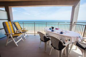a balcony with a table and chairs with a view of the ocean at Apartamentos Guillem in Playa de Miramar
