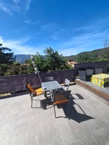 a patio with a table and chairs on a roof at LE REFUGE DES CASCADES in Vernet-les-Bains