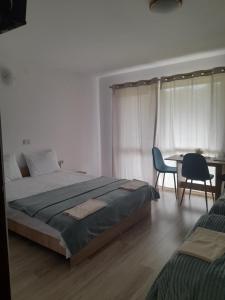 a bedroom with a bed and a table and chairs at Cabana Andrea in Arpaşu de Sus