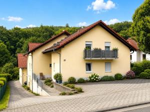 a house with a balcony on a driveway at LohainsLodge in Burbach
