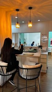 a woman sitting at a counter in a kitchen at Pepe Hostel Boutique in Neuquén