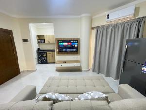 a living room with a couch and a flat screen tv at Downtown Keys in Hurghada