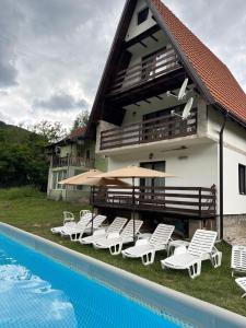 a house with chairs and a swimming pool next to it at Vila Bosa - Stara planina in Crni Vrh