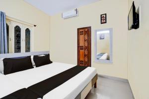 a bedroom with a white bed and a mirror at Hotel O Bluestar in Bangalore +21 photos