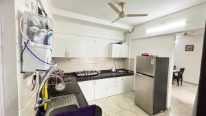 a kitchen with white cabinets and a refrigerator at Nestoria Corporate Services in Pune