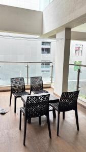 two chairs and a table in a room with windows at Nestoria Corporate Services in Pune